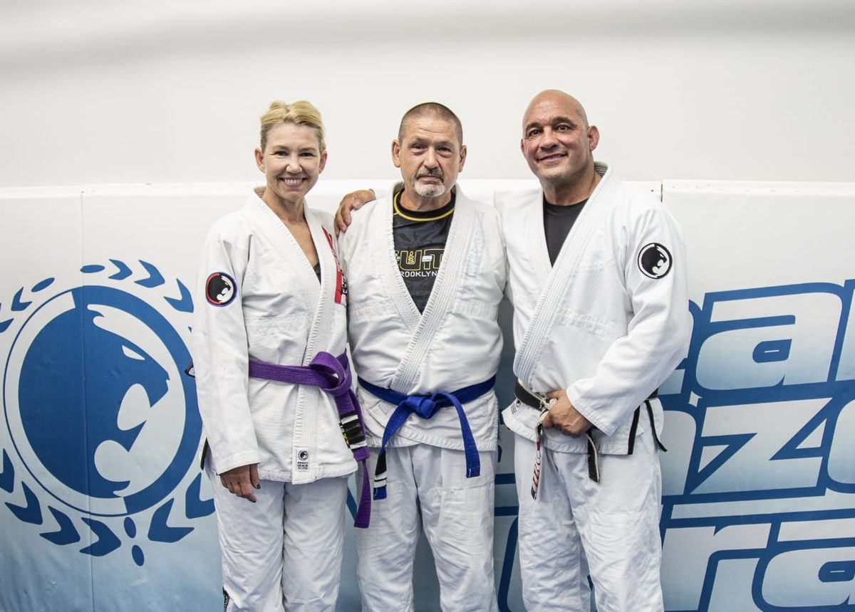 Professor Mark Cerrone with two adult members in gis after a belt promotion at Renzo Gracie Milford