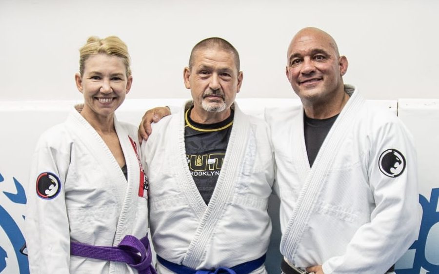Professor Mark Cerrone with two adult members in gis after a belt promotion at Renzo Gracie Milford