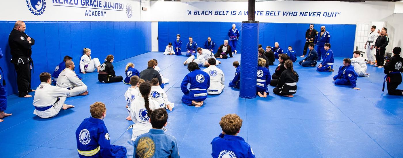 Kids jiu jitsu class seated on the mats at Renzo Gracie Jiu Jitsu Academy Milford