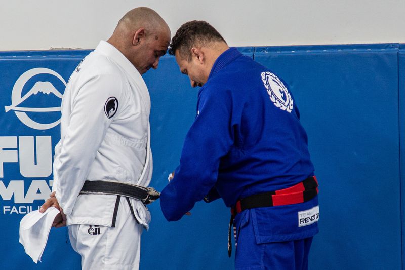 Renzo Gracie tying the black belt of Head Professor Mark Cerrone in New York