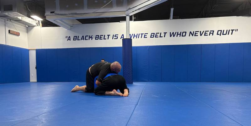 Two students grappling on the blue mat at Renzo Gracie Milford