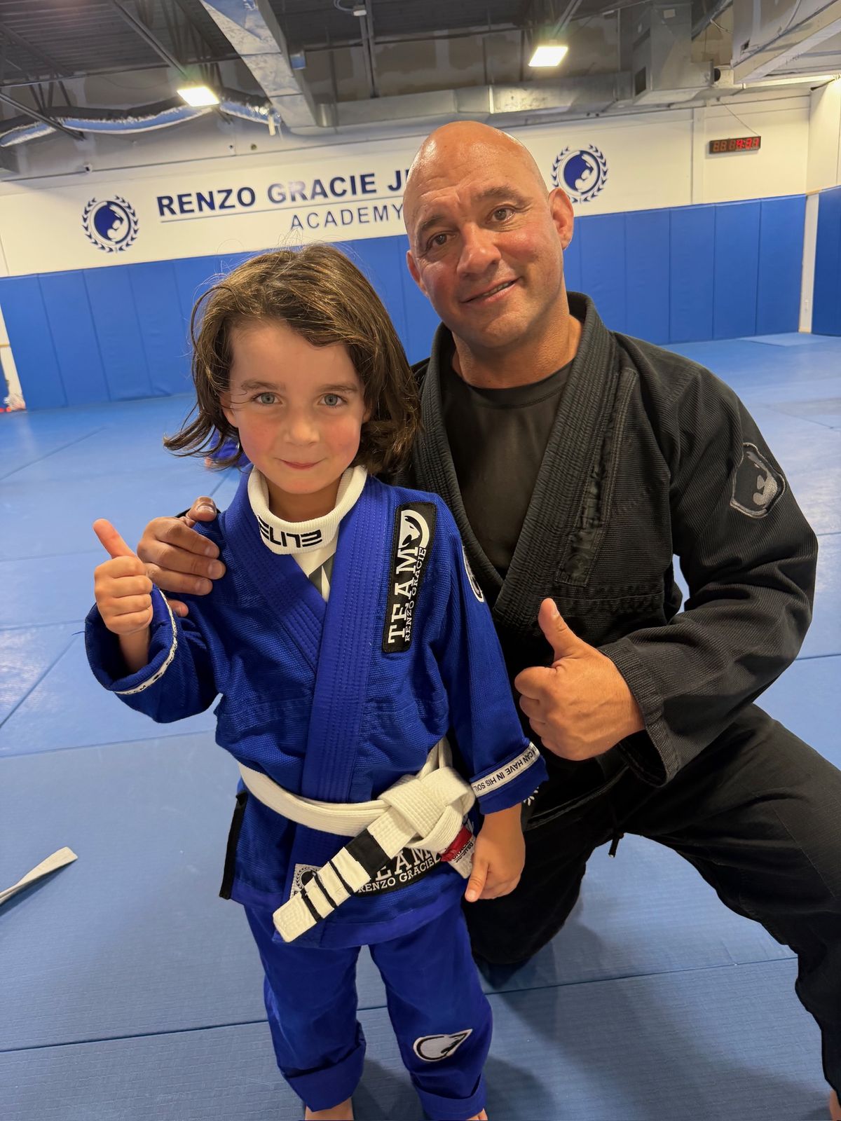 Head Professor Mark Cerrone and a young student giving a thumbs up on the mat at Renzo Gracie Milford